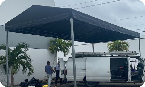 Steel-frame commercial awning sheltering work van and tools