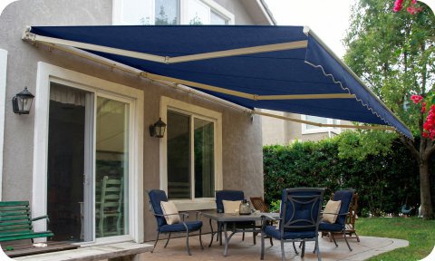 Motorized retractable awning extended over backyard patio seating area