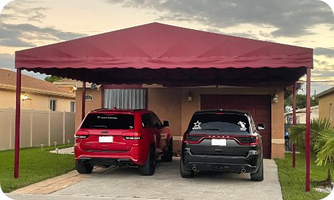 Freestanding residential awning covering two parked cars in a driveway