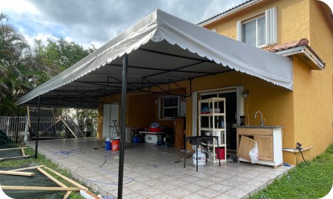 Residential patio awning providing shade over tiled outdoor living area