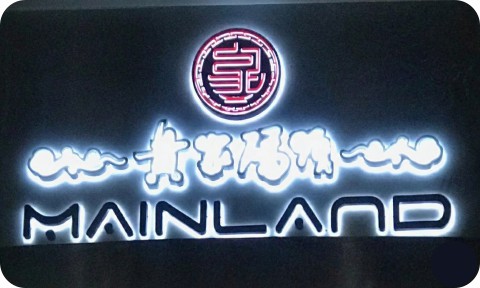Reverse channel letters sign illuminated for a storefront, displaying halo‑lit lettering on dark background